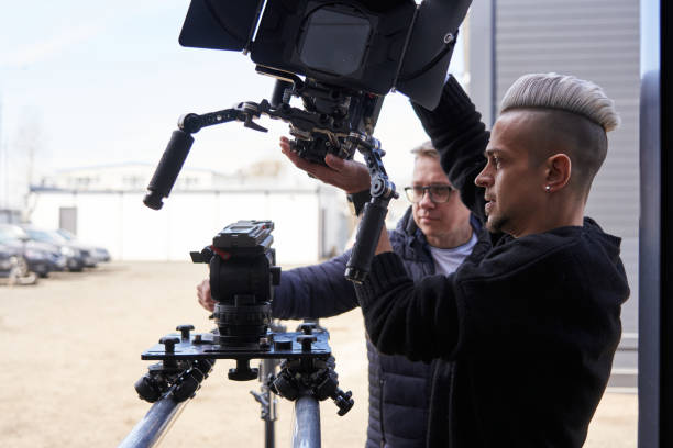 istock two caucasian men install a large professional camera on a camera trolley with wheels on rails 1471423533