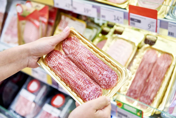 istock Sliced sausage in hands in store 1471429787