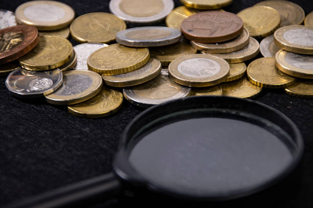 istock Coin collection and magnifying glass on black cloth 1471429986