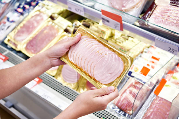 istock Woman chooses pork ham at store 1471430049