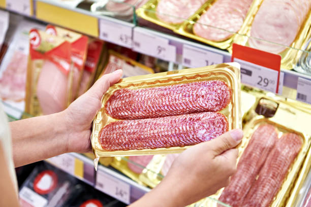 istock Sliced sausage in hands in store 1471430099