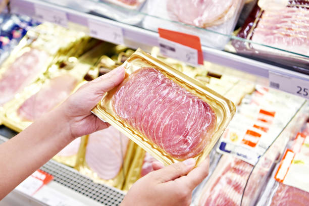 istock Woman chooses pork ham at store 1471430138