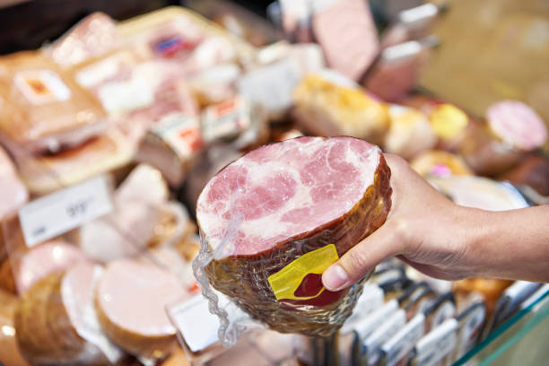 istock Woman chooses pork ham at store 1471430150