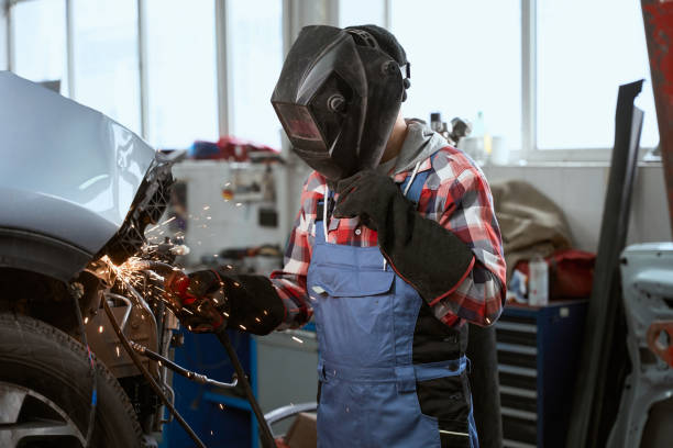 istock Welder in work overalls works in a car workshop 1471432115