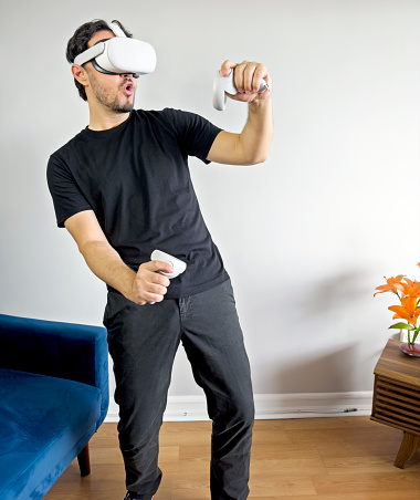 Man using a Virtual Reality headset and touching the air ( the vr headset design has been changed )