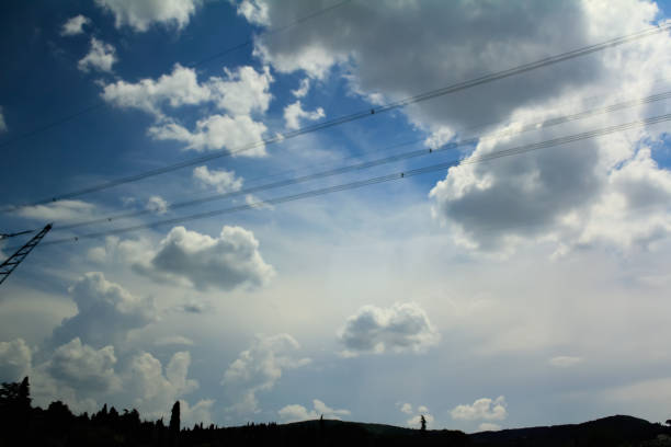 Bottom view on clouds, cumulus clouds in blue sky view from below with greenery. Looking through car window. For background, wallpaper, digital artwork use and etc..