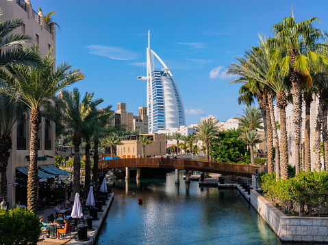 Dubai, United Arab Emirates - January 8, 2023: Iconic Burj Al Arab next to luxury resort and shopping destination Madinat Jumeirah. The resort provides luxury hotel rooms and hosts vast variety of entertainment facilities including fine dining restaurants.