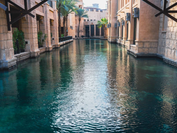 Dubai, United Arab Emirates - January 8, 2023: Low angle view of Canal passing through luxury Jumeirah Hotels and Resorts & Souk Madinat. Souk Madinat Jumeriah attracts tourists and locals alike with interesting stores and entertainment facilities including fine dining restaurants while The resort provides luxury hotel suites.