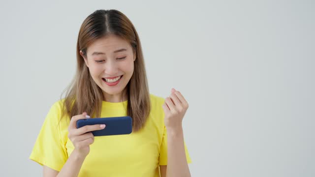 excited young woman play games by mobile phone make winner gesture. female winning mobile gambling. Wow face expression. Esport streaming game online, surprise, gamer, online, earning, new generation.