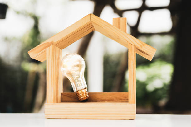 istock Light bulb with wood house on the table, a symbol for construction, Creative light bulb idea, power energy or business idea concept ecology, loan, mortgage, property or home. 1471446510