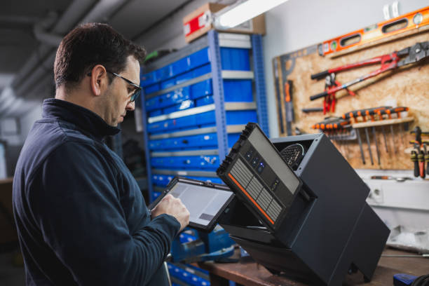 Engineer checking electronic component using a tablet in factory. stock photo