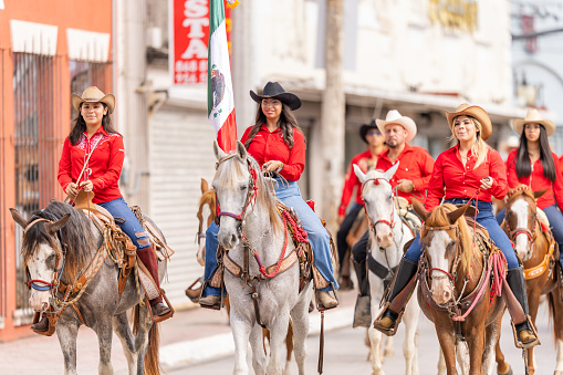 Matamoros, Tamaulipas, Mexico - September 16, 2022: Desfile 16 de Septiembre, Members of the Cuadra Cabalgantes de Matamoros riding their houses during the parade