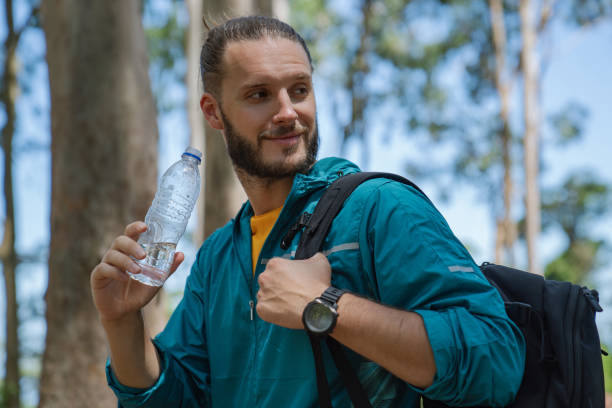 istock Close up of young man drinking water in forest 1471449518