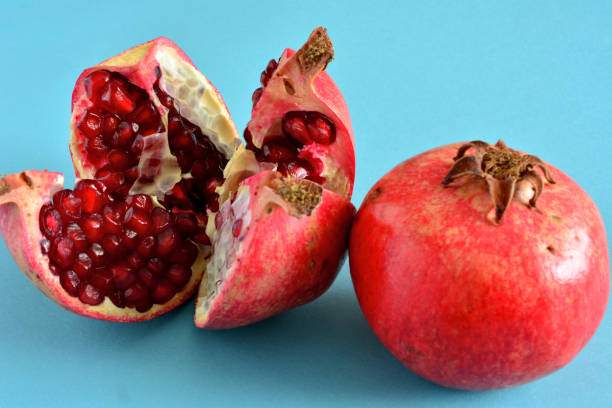 istock Pomegranates with seeds isolated on blue background, macro 1471451409