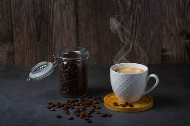 istock White espresso cup and coffee beans dark table background with copy space. Arabica grains, Coffee shop, 1471451985