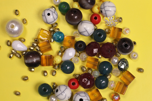 handmade beaded jewelry and multi-colored beads on a yellow background