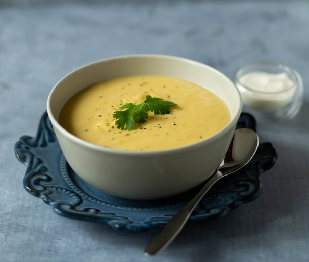 istock Pumpkin soup in a bowl with parsley on a blue plate with a spoon 1471454011