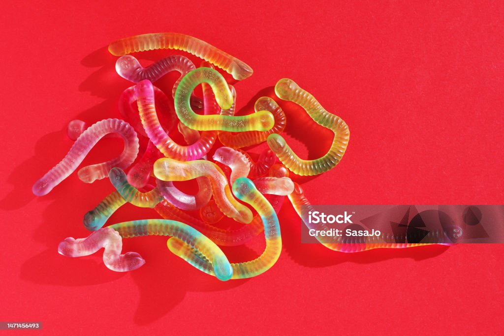 Colorful gummy worms Top view of colorful gummy worms on red background Gummy Candy Stock Photo