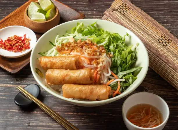 Fried Spring Rolls Cold Rice Vermicelli with sauce served in bowl isolated on table top view of taiwan food
