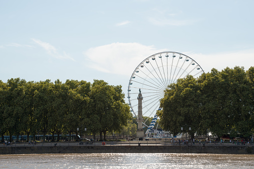 Bordeaux, France; 08092022: Fair ferris wheel at Bordeaux park. Water front seen from a boat.
