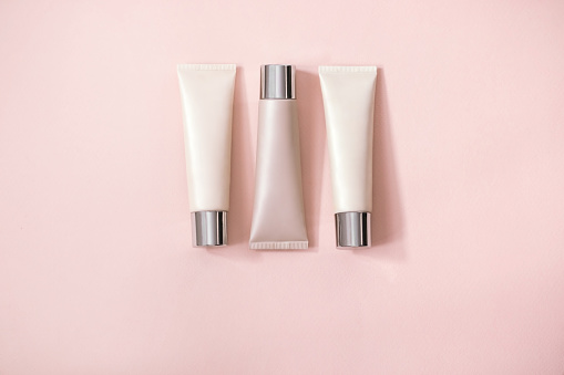 three tubes  foundation on  pale pink background