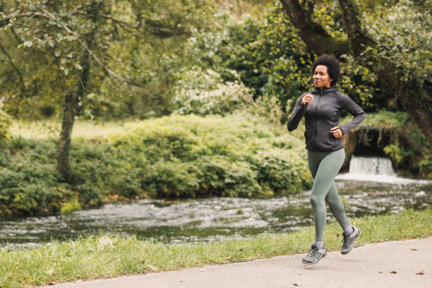 donna nera che corre nella natura - running jogging african descent nature foto e immagini stock