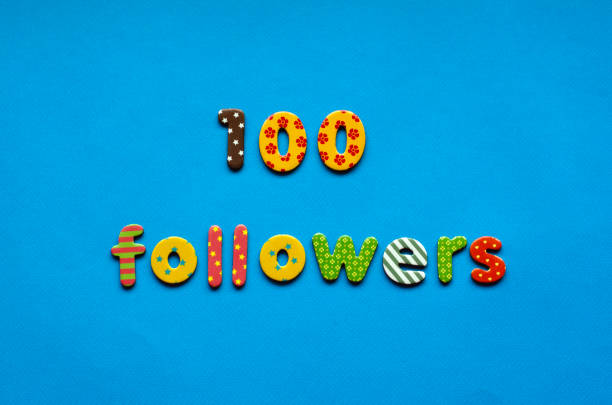 istock text 100 followers  from bright colored paper letters on blue paper background 1471462255