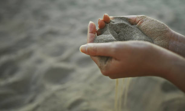 Sand slips through your fingers. Time is fleeting. stock photo