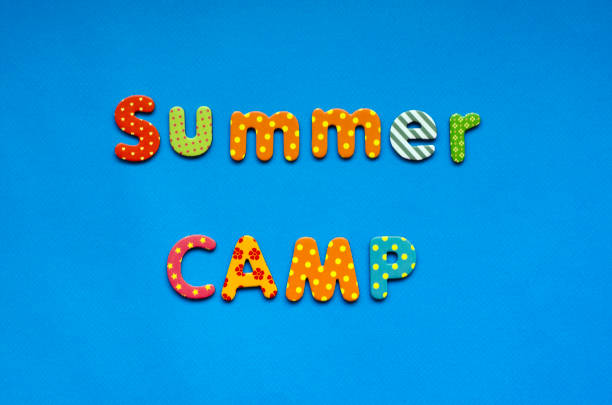 istock text summer camp from bright colored paper letters on blue paper background 1471464218