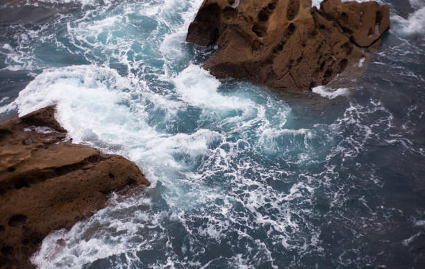 istock Waves in the ocean crash against the rocks 1471464845