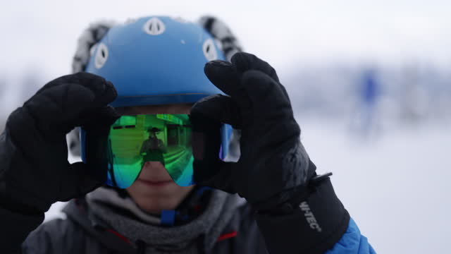 Portrait of a cool teenage skier on the mountain peak preparing to ski.