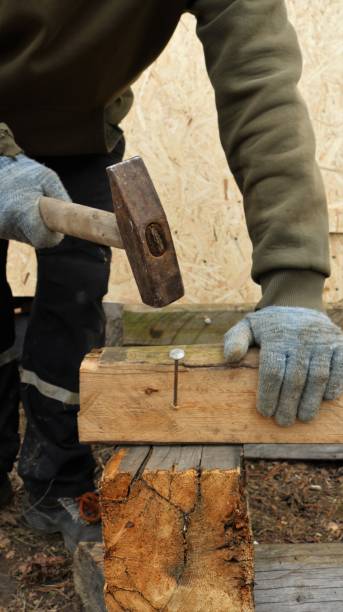 istock a worker hammers a nail into a beam of old wood 1471468727