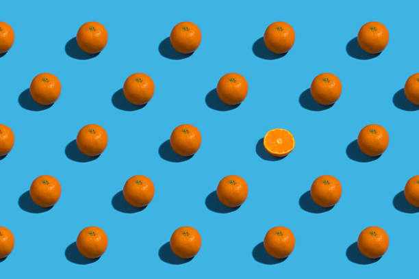 istock Fresh oranges in a row with one in half on a bright blue background 1471472162