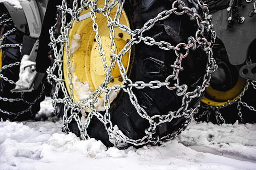 close up of a Snowplow wheel with snow chains.