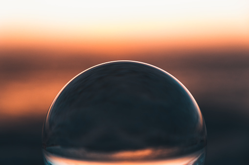 Close up abstract high contrast view of a lens ball in the beach of Mari Ermi at sunset