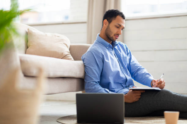 istock Portrait of young Arab man using laptop and writing 1471477832