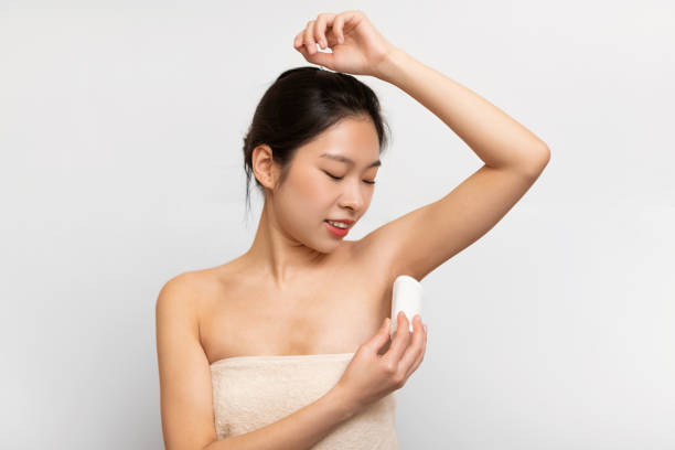 istock Young Asian woman using applying deodorant in bathroom 1471478086