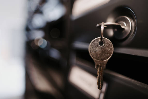 A close-up image of a key hanging on black mailboxes with a blurry backgr. Perfect for real estate investment, rental property, house buying, parcel pick up, delivery