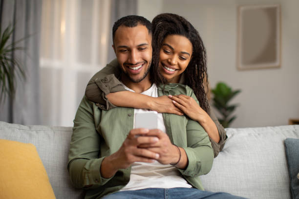 istock Happy African American Couple Using Mobile Phone At Home 1471478275