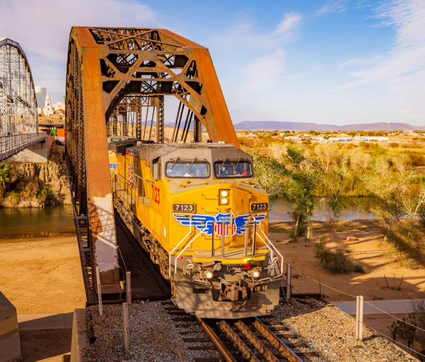 Yuma, AZ / USA - 02/21/2023: A shot of a Union Pacific locomotive while crossing a trestle over the Colorado river in Yuma, AZ.