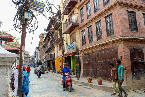 Nepal, Lalitpur - May 10, 2019: Traditional nepalese city street with few walking people in downtown district. Soft focus. Travel in Nepal theme.