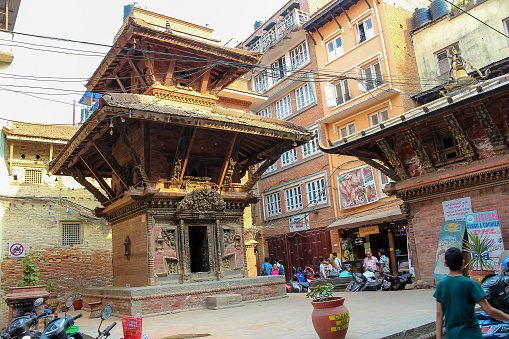 Nepal, Lalitpur - May 10, 2019: Small pagoda style hindu temple on Mwaamadu Galli street in downtown district in a sunny day. Soft focus. Religious architecture theme.