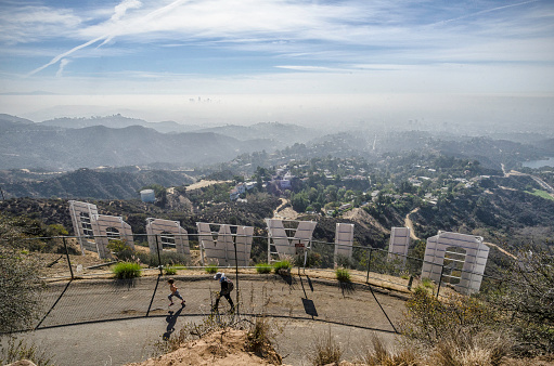 Los Angeles, CA, USA, October 25, 2013: A mother and child walk up Mount Lee Drive behind the Hollywood sign in Los Angeles, CA.