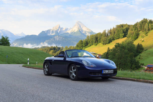 niebieski roadster porsche boxster 986 z górą watzmann i panoramą mgły. samochód to dwumiejscowy samochód sportowy z silnikiem umieszczonym centralnie produkowany przez porsche. - germany landscape nissan roadster zdjęcia i obrazy z banku zdjęć