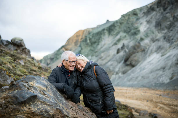 istock Smiling senior couple taking break while hiking though on volcanic mountain trail 1471486457