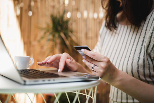 istock female hands holding credit card and using laptop. 1471486626