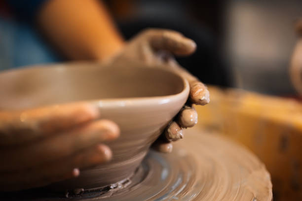istock Close up on skillful hands sculpting pottery jar on potter wheel 1471488215