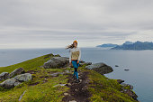 Happy female hiking on summer Lofoten Islands