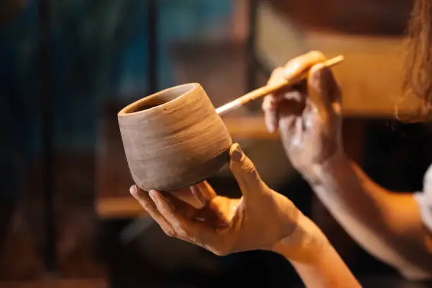 Professional craftsman potter making jug of clay on the potter's wheel circle in workshop, Traditional handicraft working, Creativity and art of pottery