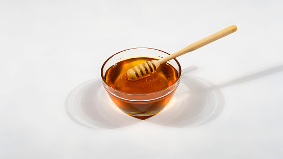 Honey flowing from stick on white background. Clipping paths.